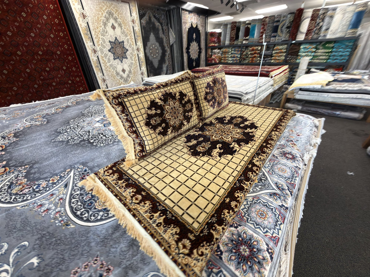 Cream grid toshak cushions with burgundy medallions, angled view