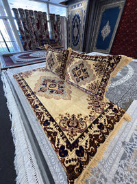 Golden cream Afghan toshak with chocolate brown border, shown at an angle with both cushions