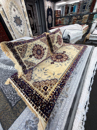 Angled view showing the fringed edge and navy floral border of the cream Afghan toshak