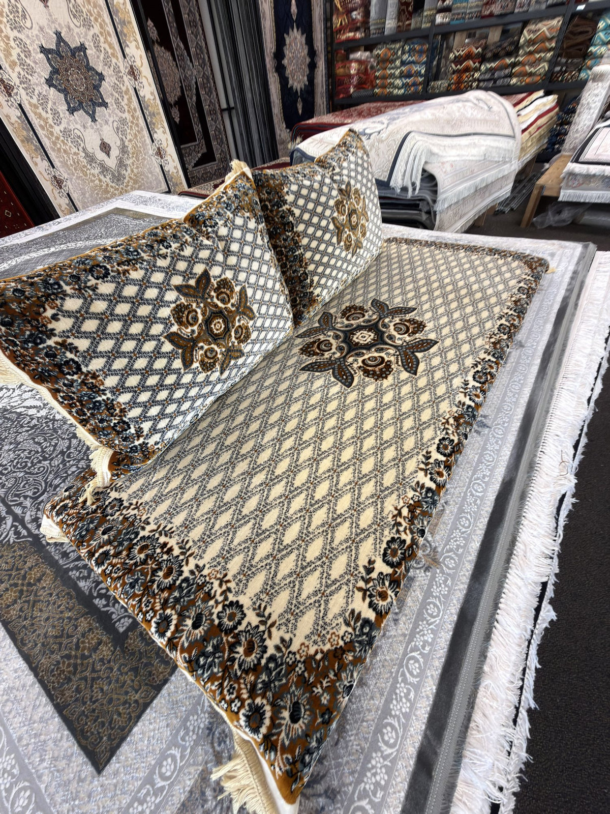 Detail of the diamond lattice and floral border on the ivory Afghan toshak cover